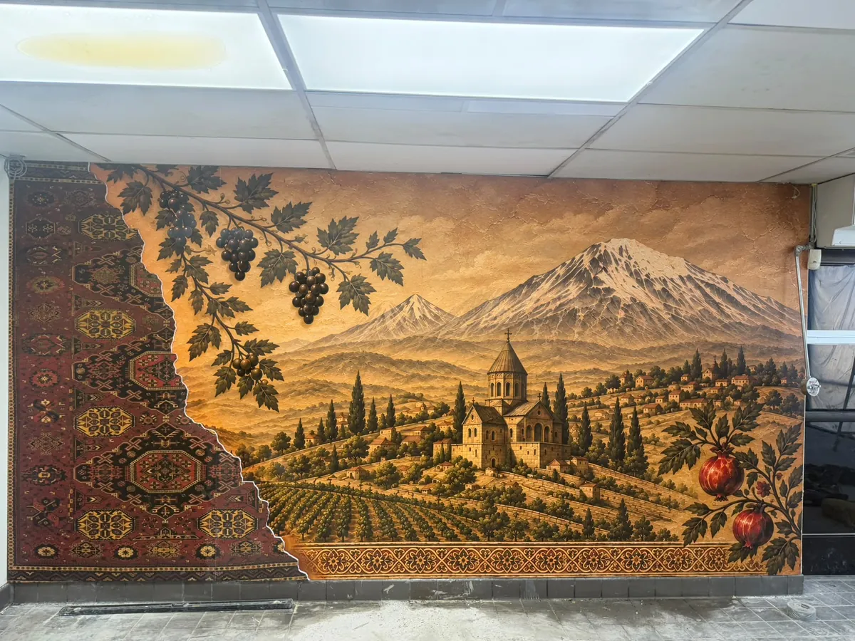 A wide printed wall mural of mountains, vineyards and a church, with a carpet pattern on the left